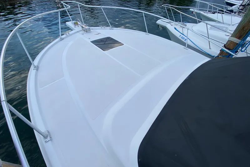 Slide: The Image of 1994 Luhrs 32 Convertible boat deck with railing, docked on calm water. - 42