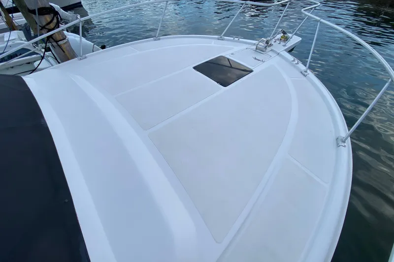 Slide: The Image of 1994 Luhrs 32 Convertible boat deck with railing, docked by the water. - 43