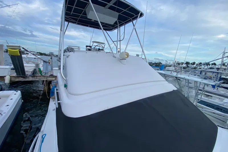 Slide: The Image of 1994 Luhrs 32 Convertible boat docked at marina under cloudy sky. - 44
