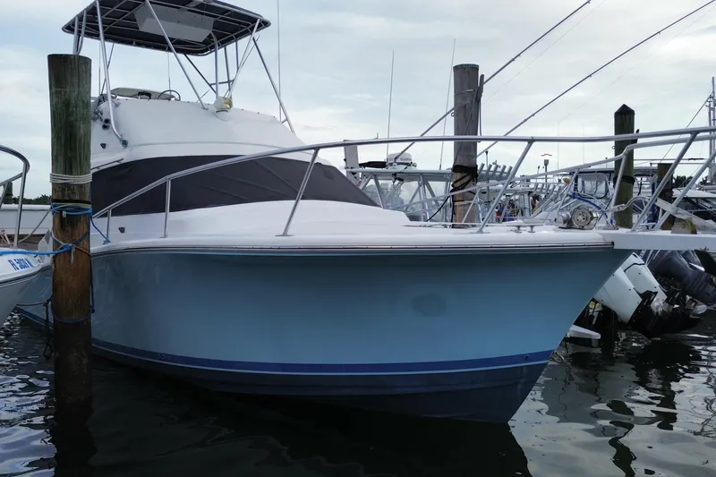 Slide: The Image of 1994 Luhrs 32 Convertible boat docked at marina, featuring sleek design and sturdy build. - 5