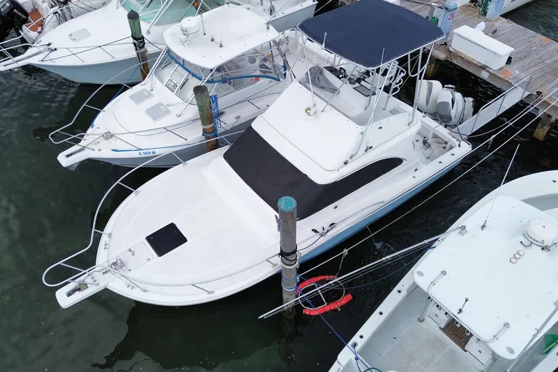 Slide: The Image of 1994 Luhrs 32 Convertible boat docked among other vessels at a marina. - 9
