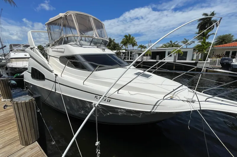 Slide: The Image of 2002 Silverton 330 Sport Bridge yacht docked at marina under blue sky. - 10