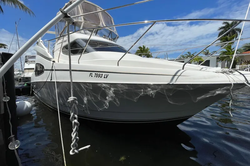 Slide: The Image of 2002 Silverton 330 Sport Bridge yacht docked, featuring sleek design and clear blue sky backdrop. - 11