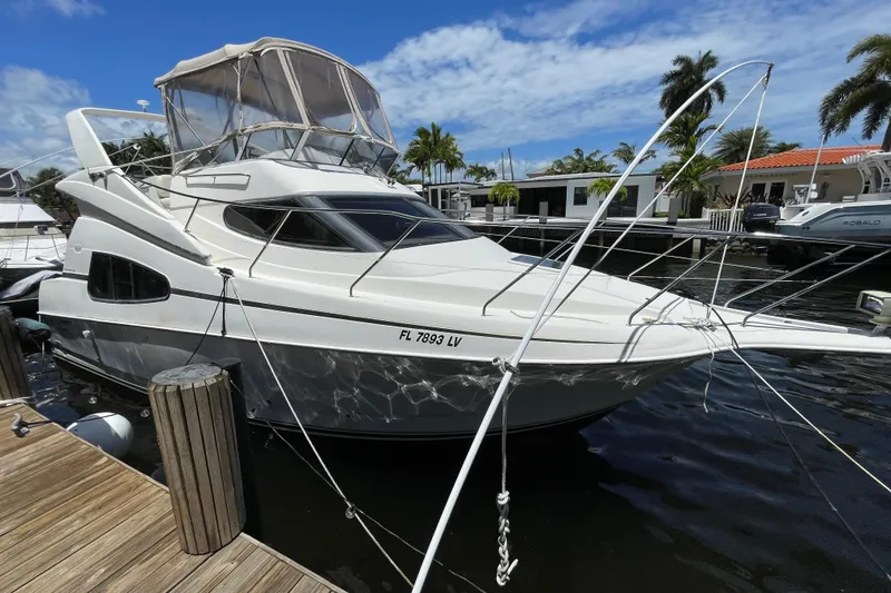 Slide: The Image of 2002 Silverton 330 Sport Bridge yacht docked at marina under blue sky. - 12