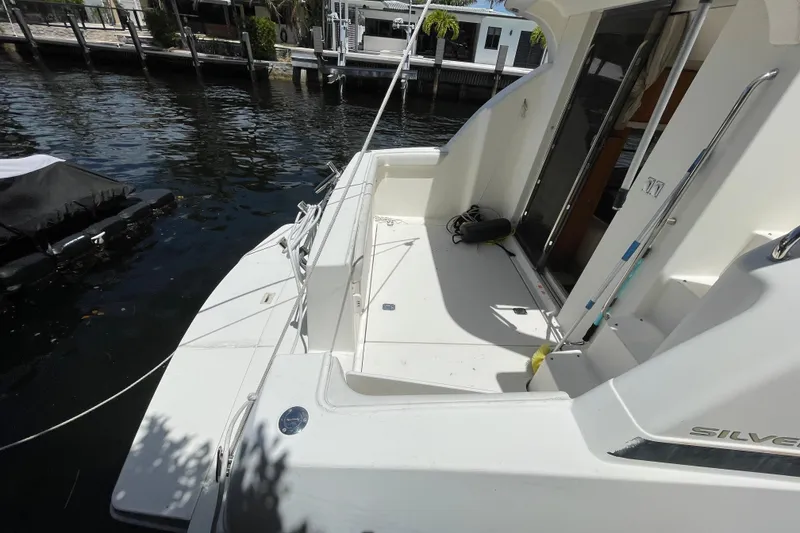 Slide: The Image of 2002 Silverton 330 Sport Bridge yacht docked by waterfront homes. - 19