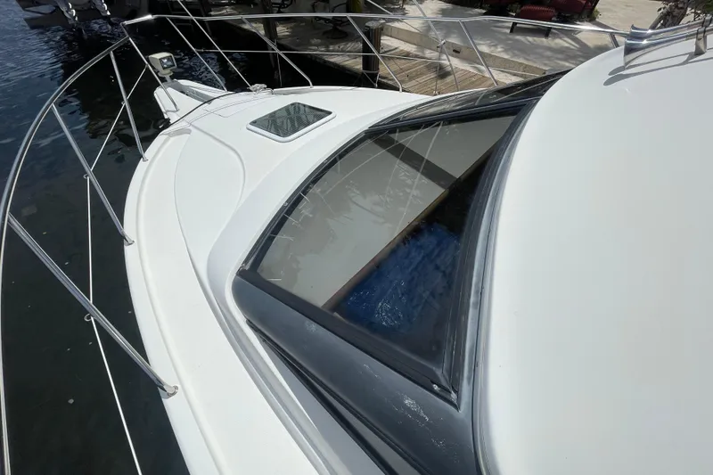 Slide: The Image of 2002 Silverton 330 Sport Bridge yacht, docked, showcasing sleek design and spacious deck. - 2