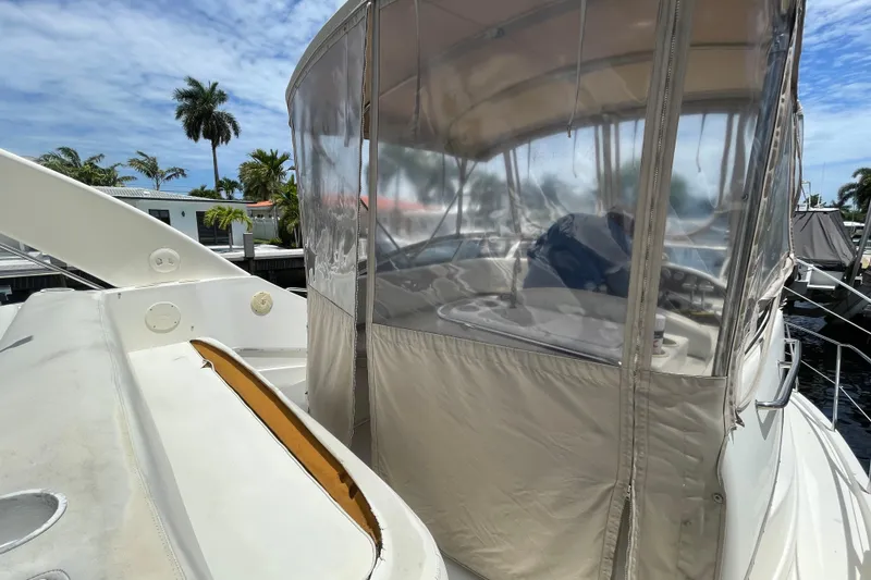 Slide: The Image of 2002 Silverton 330 Sport Bridge yacht with enclosed cockpit, docked near palm trees. - 21