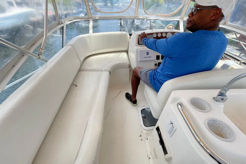 Slide: The Image of Man steering a 2002 Silverton 330 Sport Bridge boat on water. - 22