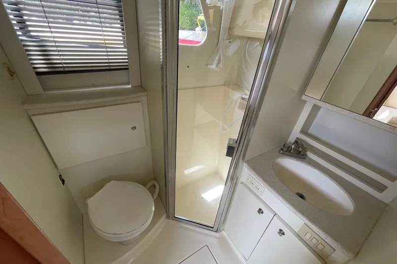 Slide: The Image of Bathroom interior of 2002 Silverton 330 Sport Bridge with shower, sink, and toilet. - 26