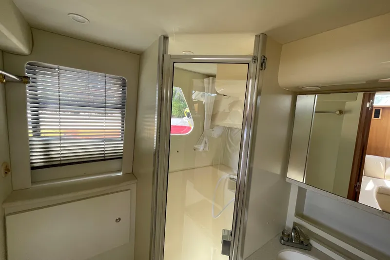 Slide: The Image of Interior of 2002 Silverton 330 Sport Bridge yacht bathroom with shower and window blinds. - 28