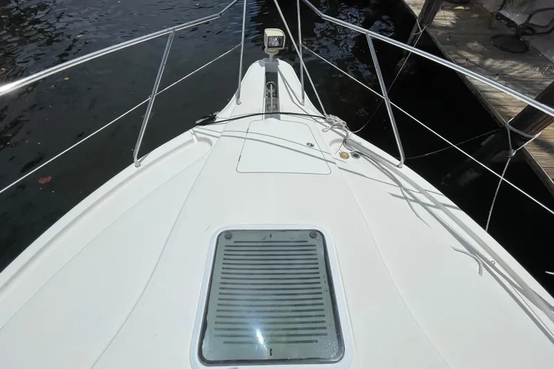 Slide: The Image of Bow view of 2002 Silverton 330 Sport Bridge yacht, docked by the water. - 3