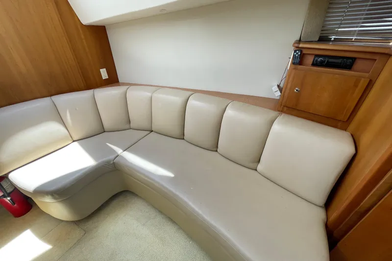 Slide: The Image of Interior of 2002 Silverton 330 Sport Bridge with beige leather seating and wooden cabinetry. - 31