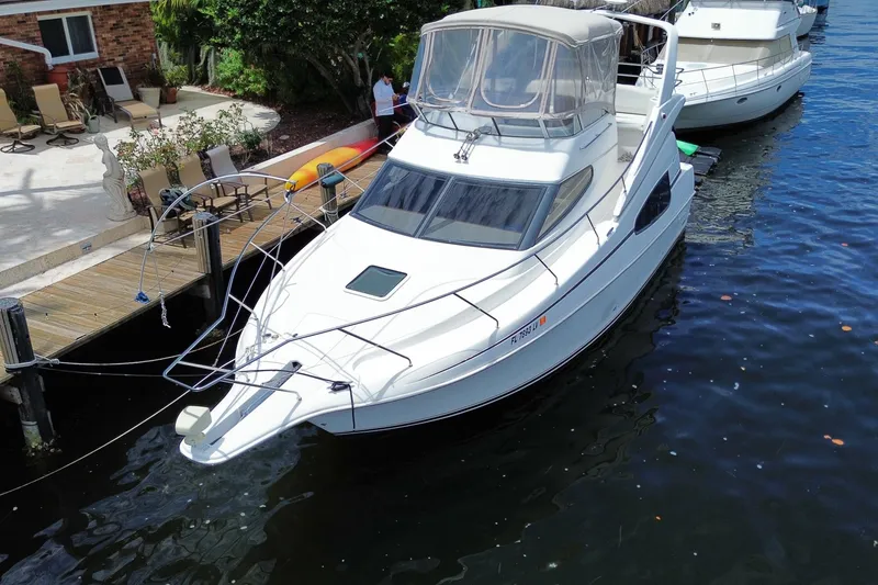 Slide: The Image of 2002 Silverton 330 Sport Bridge yacht docked by a waterfront patio. - 48