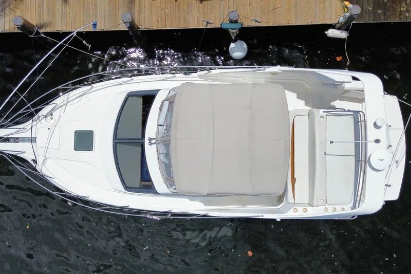 Slide: The Image of Overhead view of a 2002 Silverton 330 Sport Bridge yacht docked at a wooden pier. - 50