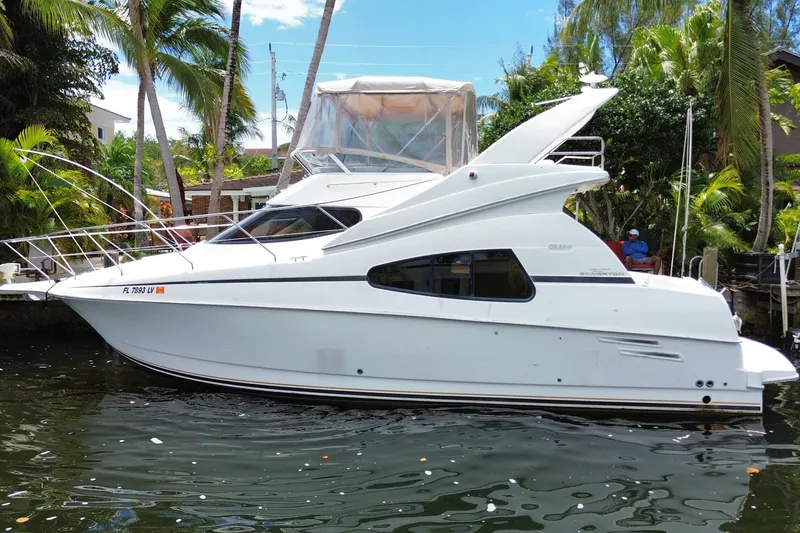 Slide: The Image of 2002 Silverton 330 Sport Bridge yacht docked by tropical palm trees. - 57