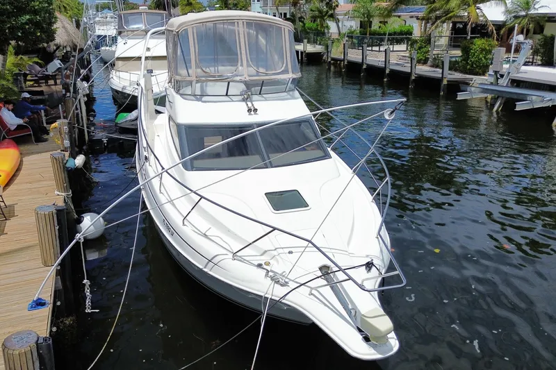 Slide: The Image of 2002 Silverton 330 Sport Bridge yacht docked by a wooden pier. - 67