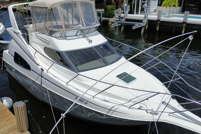 Slide: The Image of 2002 Silverton 330 Sport Bridge yacht docked in a marina. - 68