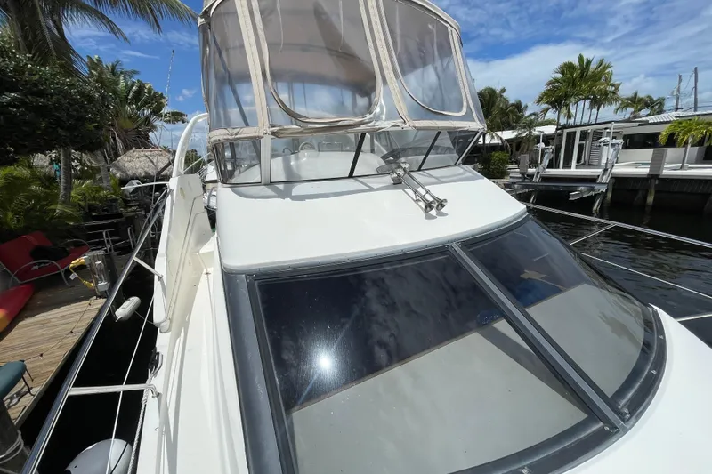 Slide: The Image of 2002 Silverton 330 Sport Bridge yacht docked near tropical palm trees. - 7