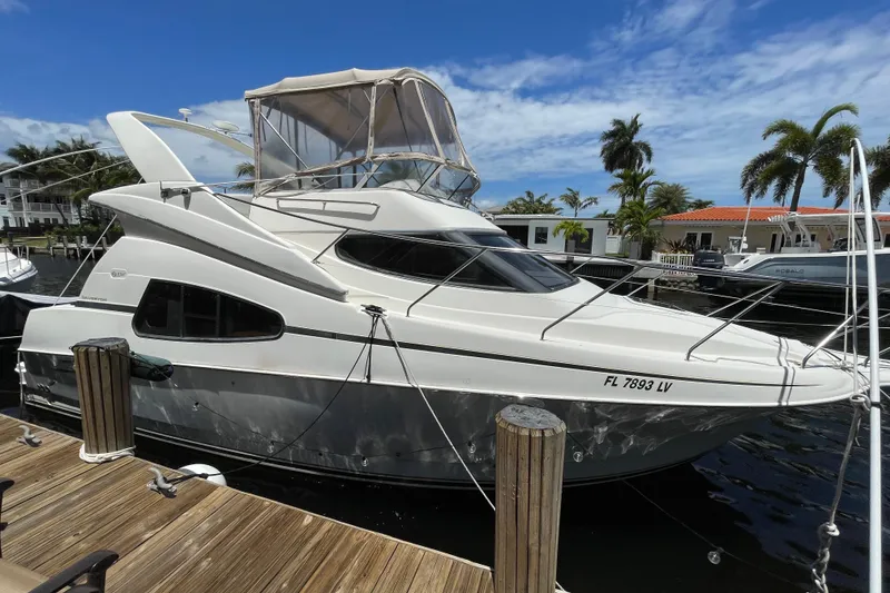 Slide: The Image of 2002 Silverton 330 Sport Bridge yacht docked, featuring sleek design and spacious upper deck. - 9