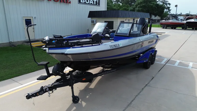 Slide: The Image of 2025 Vexus DVX22S boat on trailer outside store. - 10