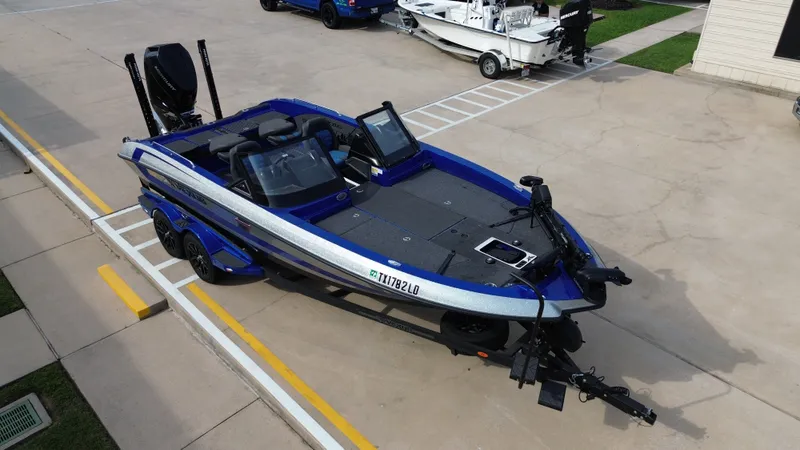 Slide: The Image of 2025 Vexus DVX22S boat on trailer, blue and silver, in parking lot. - 17