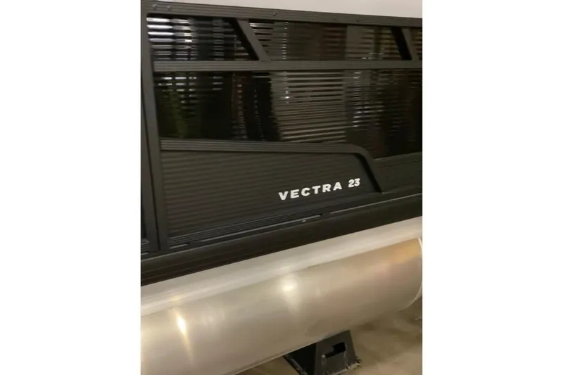 Slide: The Image of 2026 Princecraft Vectra 23 QL pontoon boat, side view with sleek black design. - 3