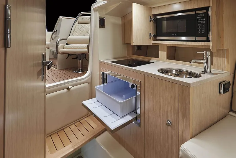 Slide: The Image of Manufacturer Provided Image: 2020 Chris-Craft Corsair 34 interior kitchen with microwave, sink, and seating area. - 9