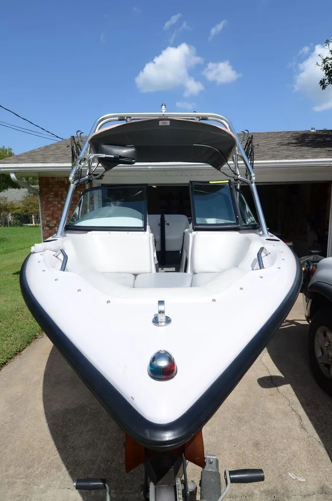 Slide: The Image of 2001 Correct Craft Air Nautique boat parked in a driveway. - 2
