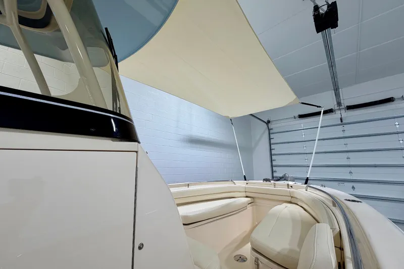 Slide: The Image of 2023 Grady-White Fisherman 257 boat interior with seating and canopy in a garage. - 27