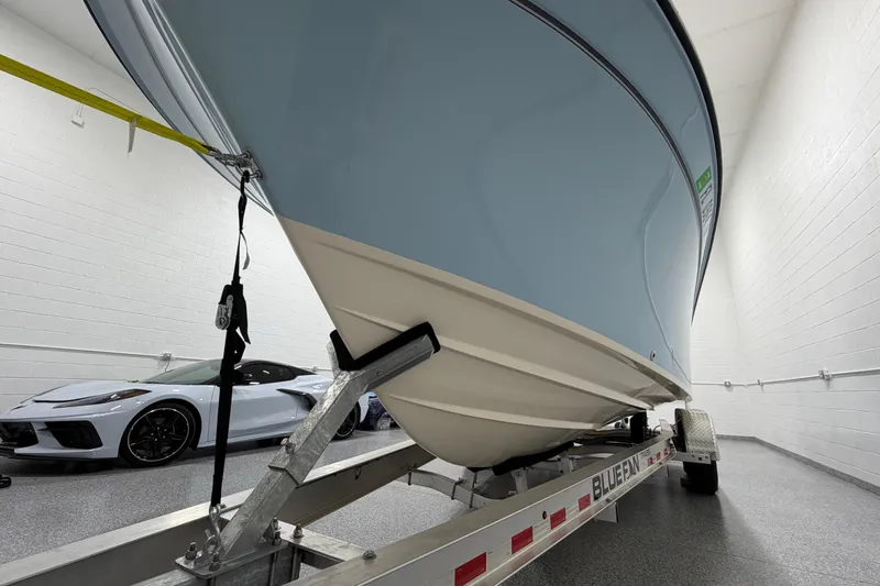 Slide: The Image of 2023 Grady-White Fisherman 257 boat on trailer in garage, alongside a sports car. - 7
