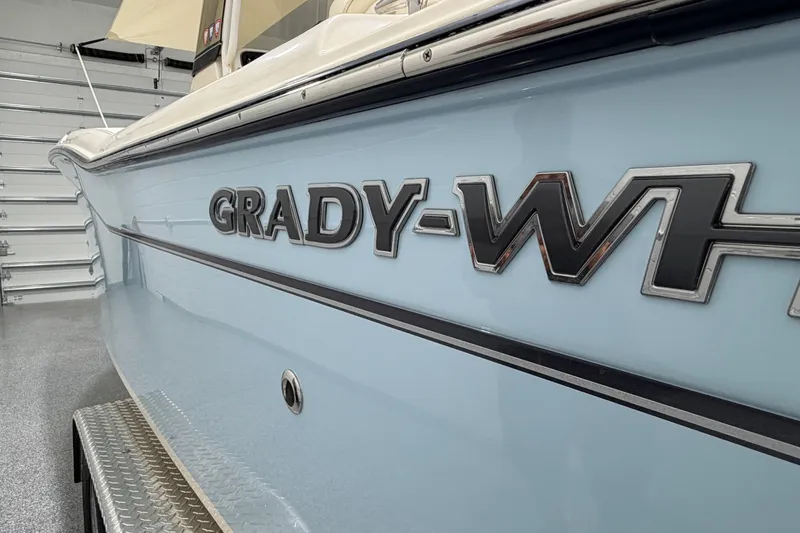Slide: The Image of 2023 Grady-White Fisherman 257 boat in a garage, showcasing sleek design and logo. - 8