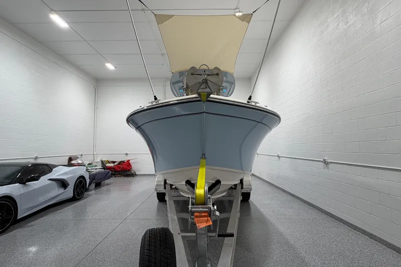 Slide: The Image of 2023 Grady-White Fisherman 257 boat on trailer in garage, next to a sports car. - 9