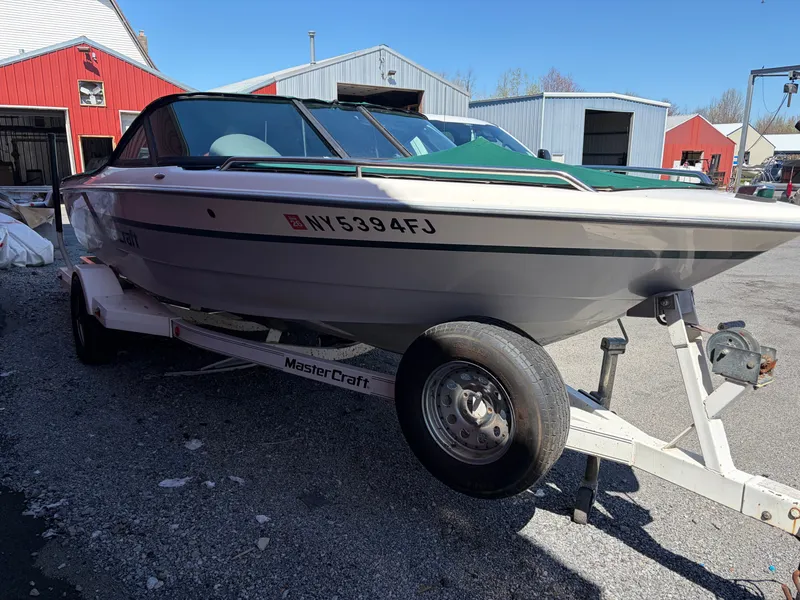 Slide: The Image of 1997 MasterCraft Prostar 205 boat on trailer in front of red buildings. - 3