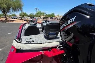 Slide: The Image of 2025 Tracker Pro Team 175 boat with Mercury engine, parked outdoors under clear blue sky. - 3