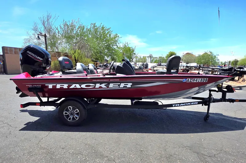 Slide: The Image of 2025 Tracker Pro Team 175 boat on trailer, red color, parked outdoors. - 5