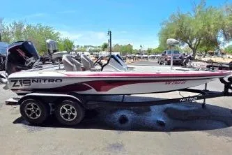 The Image of 2019 Nitro Z19 Pro boat on trailer, parked outdoors under clear blue sky. - 1