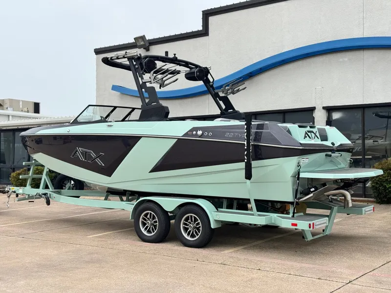 Slide: The Image of 2026 ATX Surf Boats 22 Type-S on trailer outside building. - 3