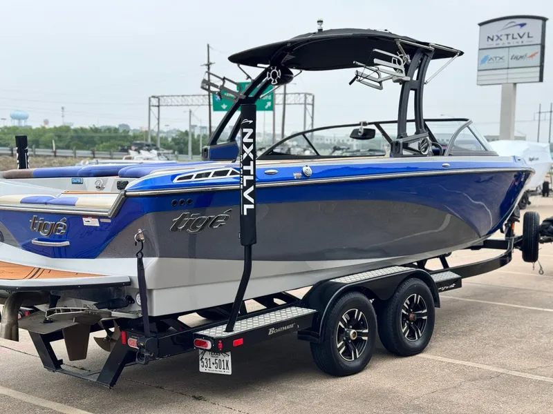 Slide: The Image of 2018 Tigé R23 boat on trailer, blue and gray, side view. - 5