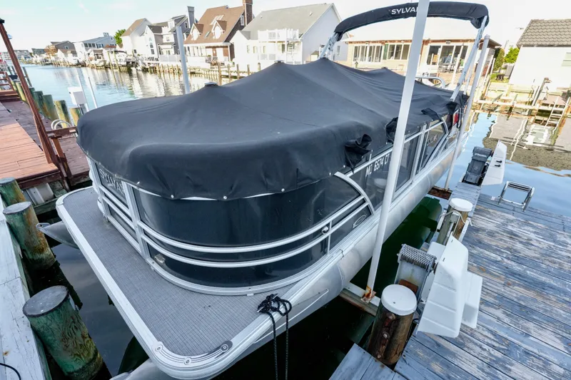 Slide: The Image of 2020 Sylvan Mirage 8522 Cruise pontoon boat docked with cover on, in a residential marina. - 14