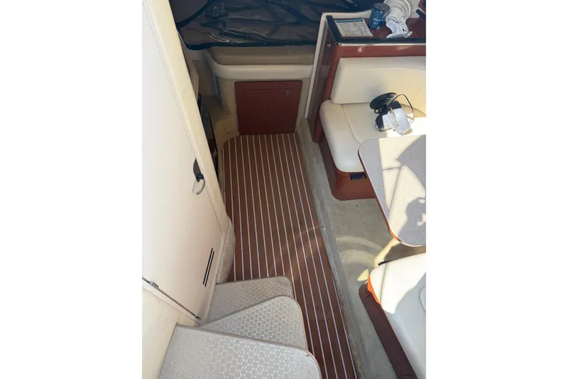 Slide: The Image of 2005 Sea Ray 290 Amberjack cabin interior with seating and wooden flooring. - 10