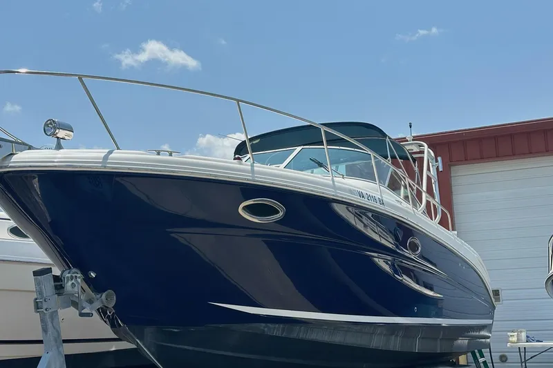 Slide: The Image of 2005 Sea Ray 290 Amberjack boat with blue hull, docked under clear sky. - 2