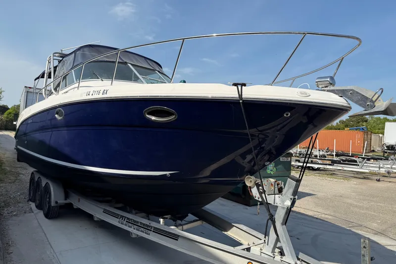 Slide: The Image of 2005 Sea Ray 290 Amberjack boat on trailer, blue hull, parked outdoors. - 4