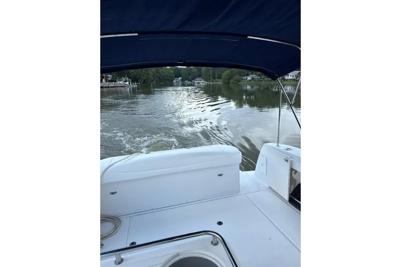 Slide: The Image of 2005 Sea Ray 290 Amberjack cruising on a calm river under a blue canopy. - 5