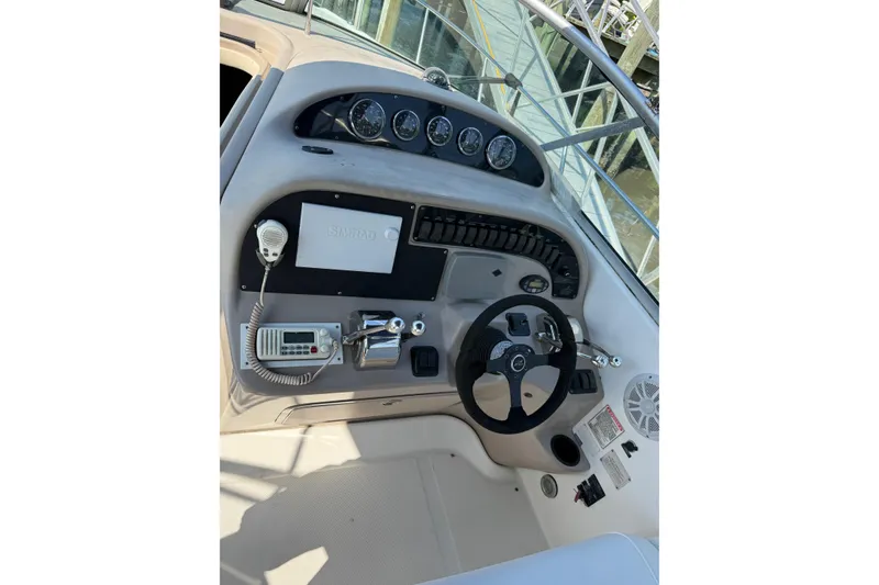 Slide: The Image of 2005 Sea Ray 290 Amberjack helm with steering wheel, gauges, and marine radio. - 7