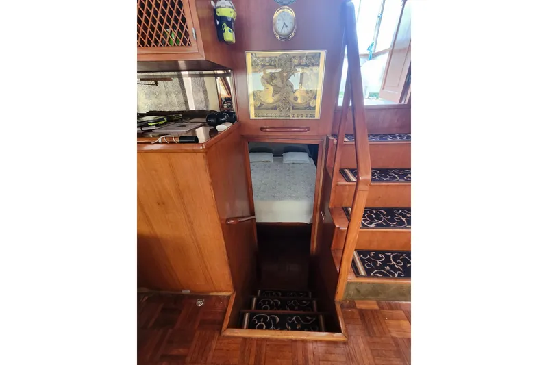Slide: The Image of Interior of 1988 Marine Trader 43 yacht, featuring wooden stairs and cozy cabin entrance. - 10