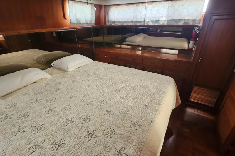 Slide: The Image of Luxurious bedroom interior of 1988 Marine Trader 43 yacht with elegant bedding and wood finishes. - 12