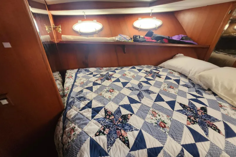 Slide: The Image of Cozy cabin interior of 1988 Marine Trader 43 with quilted bedspread and porthole windows. - 16