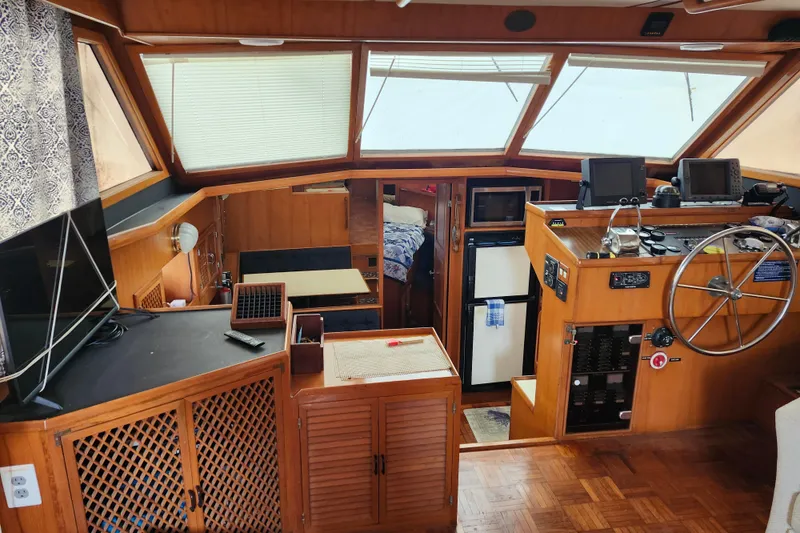 Slide: The Image of 1988 Marine Trader 43 interior with helm, navigation equipment, and cozy cabin space. - 20