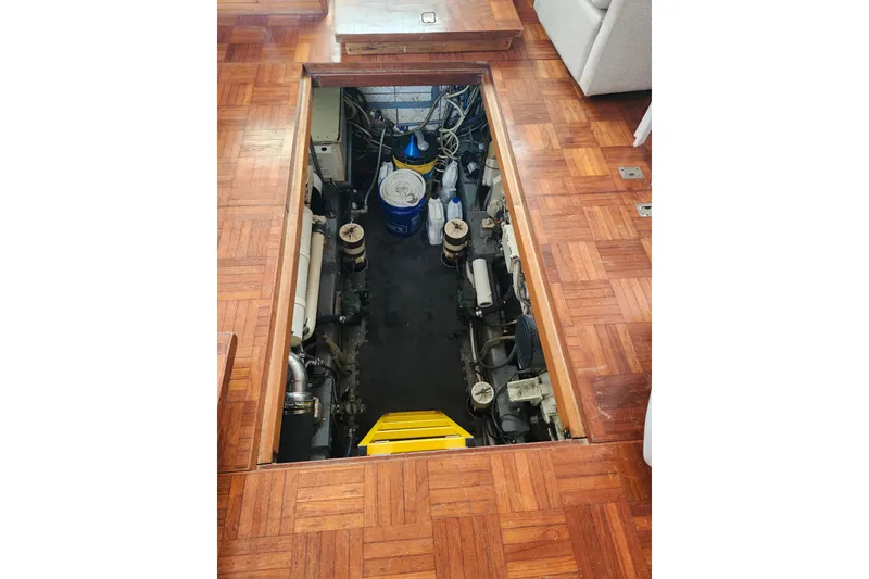 Slide: The Image of Engine room of 1988 Marine Trader 43 yacht with wooden flooring and visible machinery. - 24