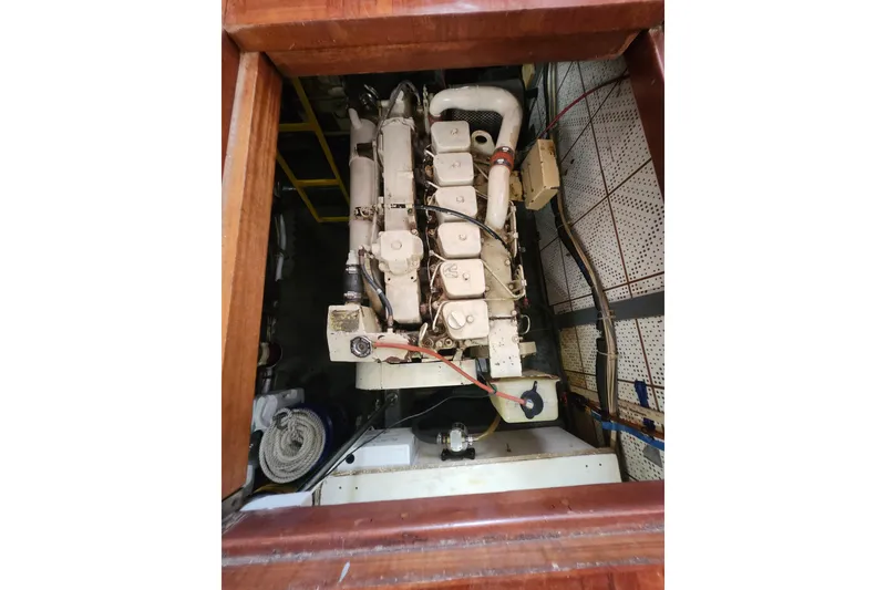 Slide: The Image of Engine room of a 1988 Marine Trader 43 yacht, showcasing the engine and surrounding components. - 25